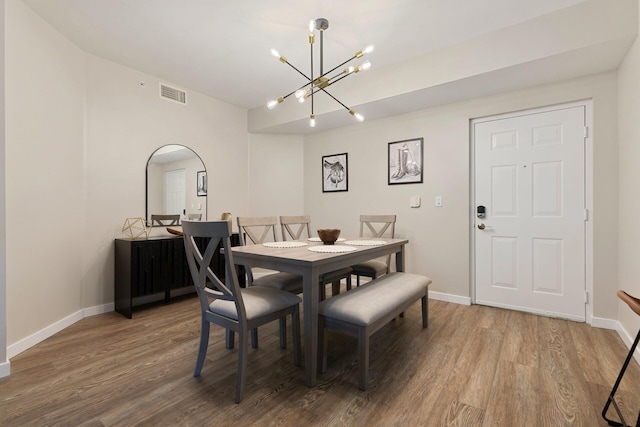 dining room with hardwood / wood-style floors and a notable chandelier