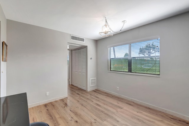 interior space with light hardwood / wood-style floors and an inviting chandelier