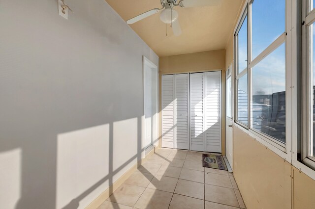 unfurnished sunroom featuring ceiling fan