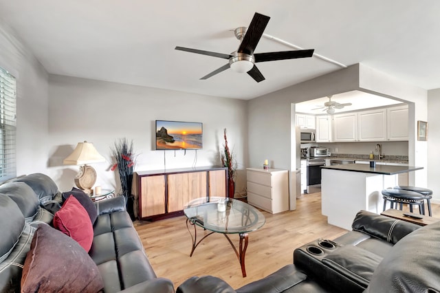 living room with light hardwood / wood-style flooring, sink, and ceiling fan