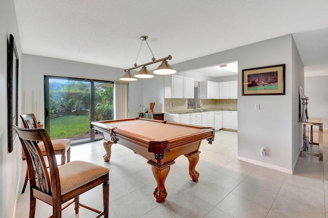 playroom with light tile patterned flooring, a textured ceiling, sink, and pool table