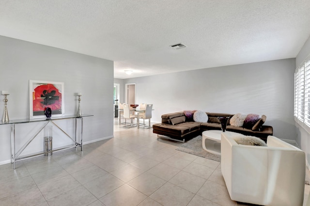 tiled living room featuring a textured ceiling