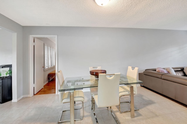 tiled dining room with a textured ceiling