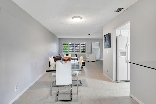 tiled dining space featuring a textured ceiling