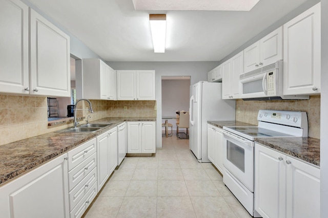 kitchen featuring white appliances, decorative backsplash, dark stone counters, and white cabinets