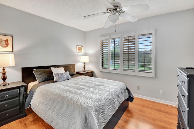 bedroom featuring light hardwood / wood-style floors, a textured ceiling, and ceiling fan