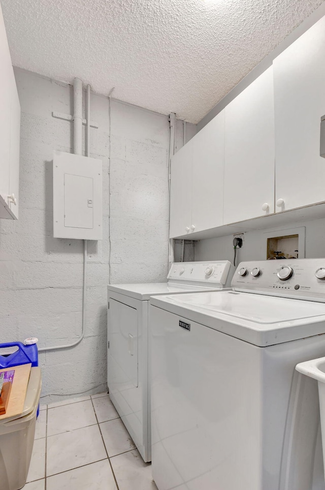 laundry area featuring cabinets, electric panel, separate washer and dryer, and light tile patterned floors