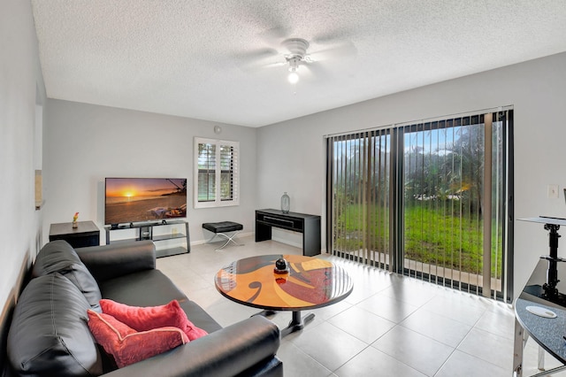 living room with a textured ceiling, light tile patterned floors, and ceiling fan