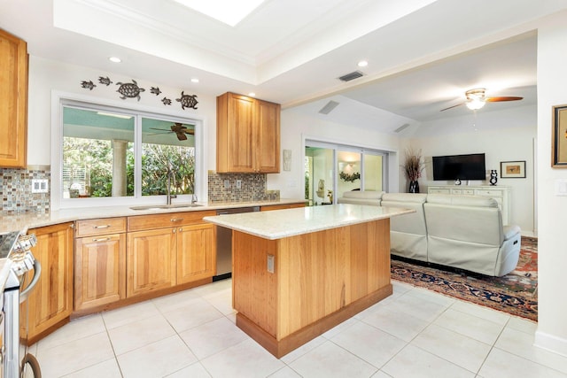 kitchen with appliances with stainless steel finishes, decorative backsplash, a center island, and sink