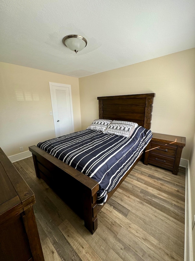 bedroom featuring a textured ceiling and hardwood / wood-style floors