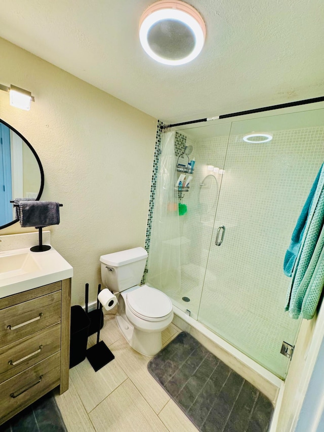 bathroom featuring vanity, an enclosed shower, toilet, and tile patterned floors