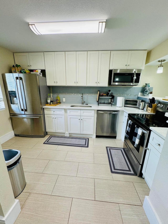 kitchen featuring sink, appliances with stainless steel finishes, white cabinets, and tasteful backsplash