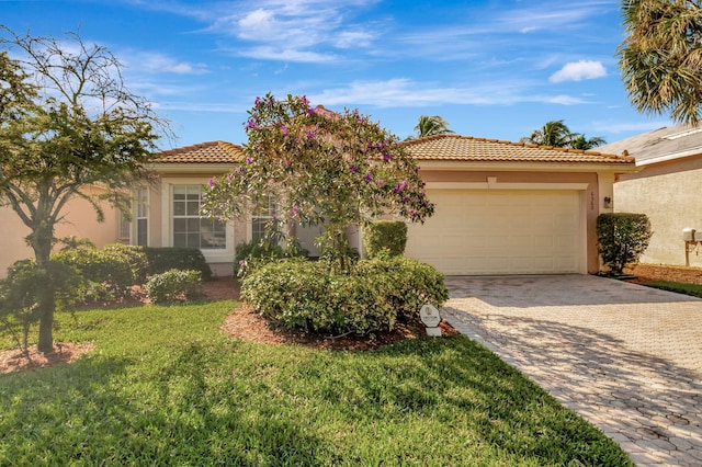 mediterranean / spanish-style home with a front yard and a garage