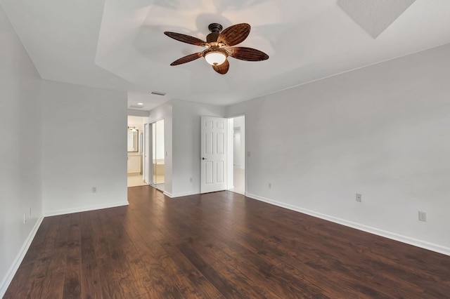 unfurnished room featuring baseboards, visible vents, hardwood / wood-style flooring, and a ceiling fan