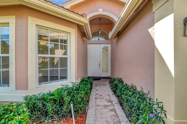 doorway to property featuring stucco siding