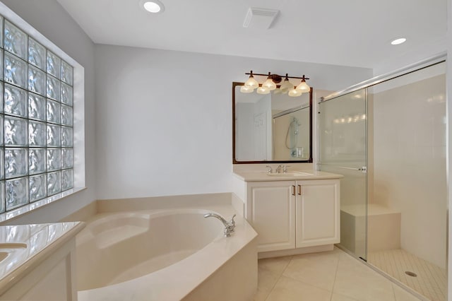full bath featuring a shower stall, a sink, two vanities, a garden tub, and tile patterned flooring
