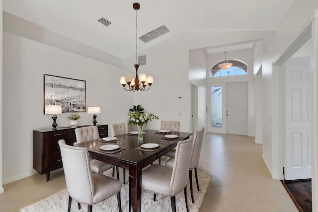 tiled dining space featuring lofted ceiling and a chandelier