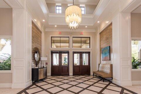 foyer featuring ornamental molding, a high ceiling, and a chandelier