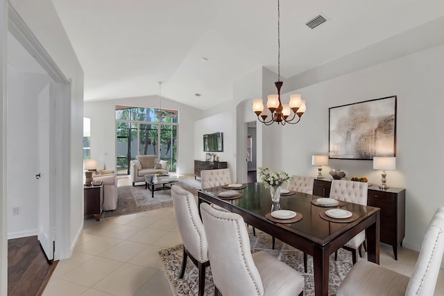dining area with lofted ceiling, light tile patterned floors, visible vents, baseboards, and an inviting chandelier
