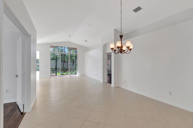 tiled empty room featuring a notable chandelier and lofted ceiling