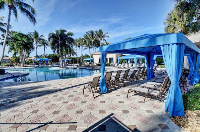 community pool with a gazebo and a patio