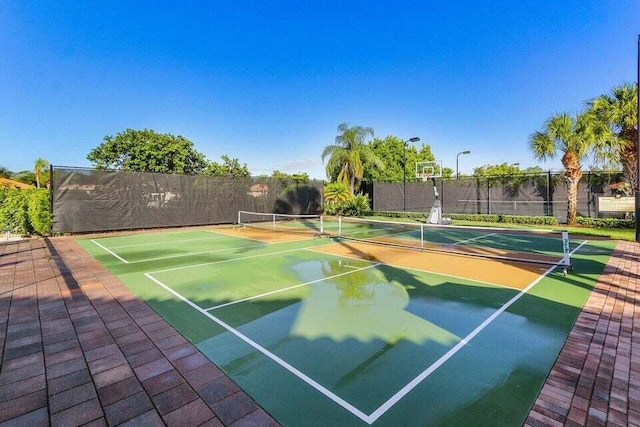 view of sport court with a tennis court, community basketball court, and fence