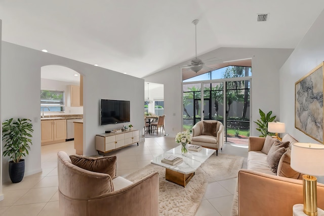 living room featuring light tile patterned floors, ceiling fan, arched walkways, and lofted ceiling