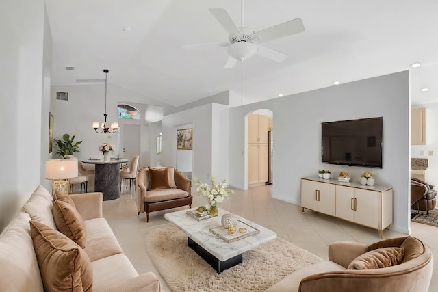 living area with visible vents, arched walkways, light tile patterned flooring, high vaulted ceiling, and ceiling fan with notable chandelier