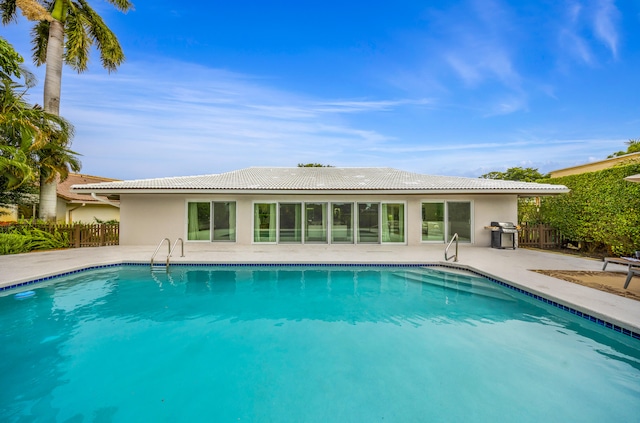 view of swimming pool featuring area for grilling and a patio area