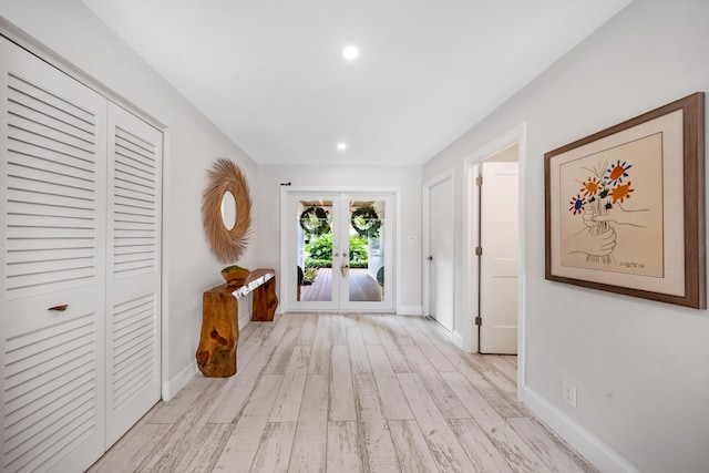 hall with light hardwood / wood-style floors and french doors