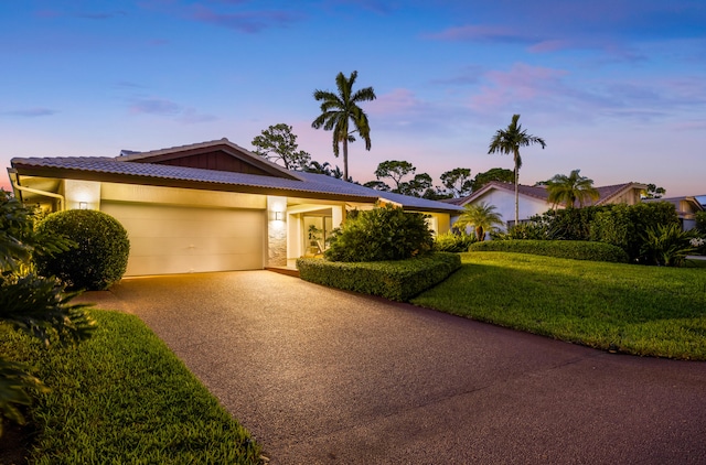 view of front facade featuring a garage and a lawn