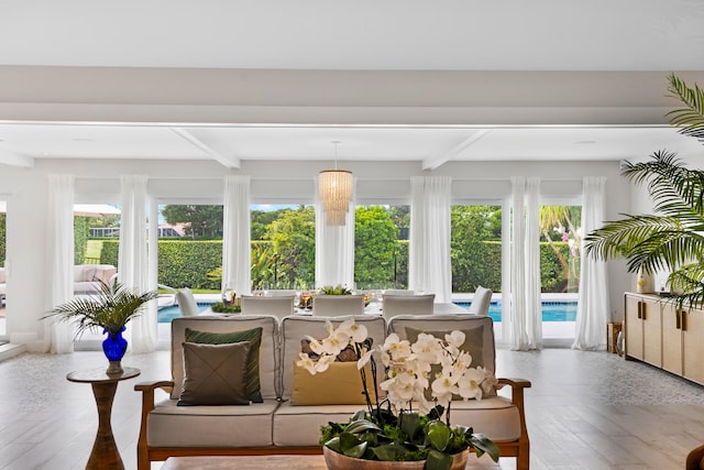 sunroom / solarium featuring a wealth of natural light and beamed ceiling