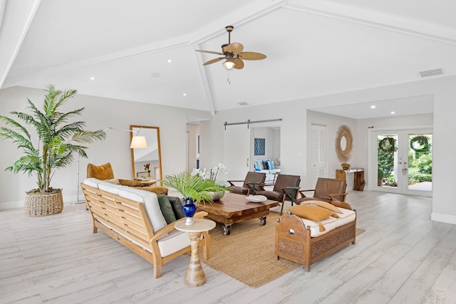 living room featuring beamed ceiling, a barn door, high vaulted ceiling, and light wood-type flooring