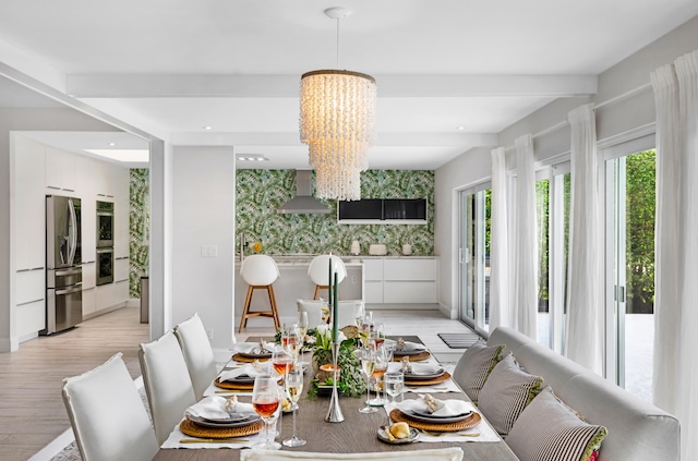 dining room with an inviting chandelier, light hardwood / wood-style flooring, and beam ceiling