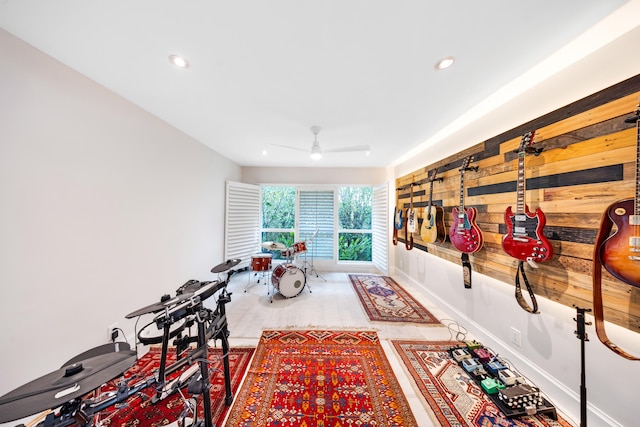 interior space with ceiling fan and wood walls