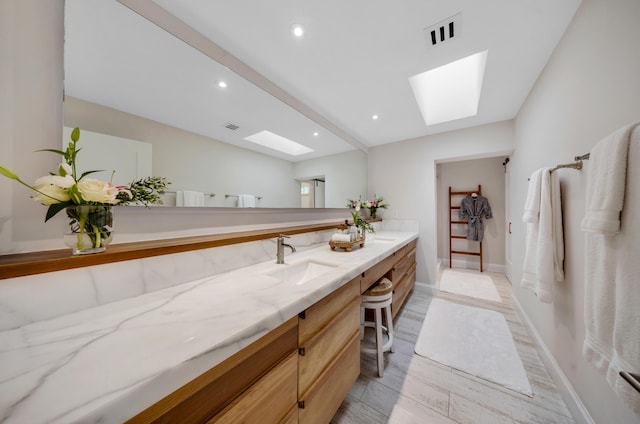 bathroom featuring vanity, hardwood / wood-style floors, and a skylight