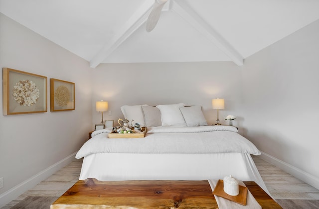 bedroom featuring light wood-type flooring and vaulted ceiling with beams