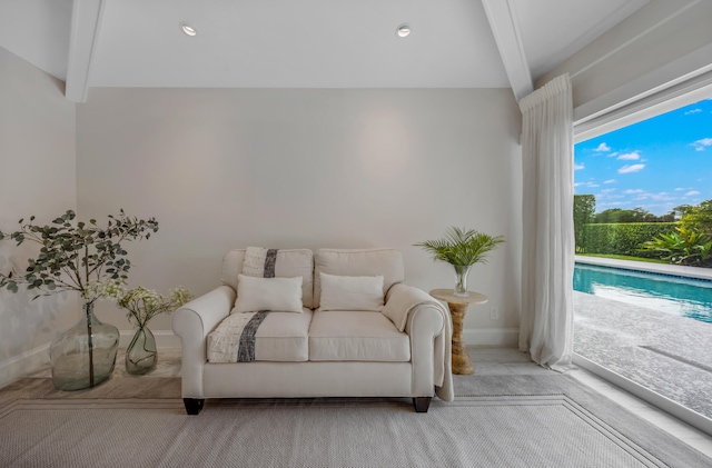 living room with beamed ceiling and light carpet