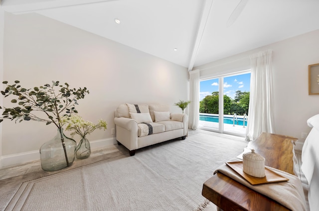 carpeted living room featuring lofted ceiling with beams