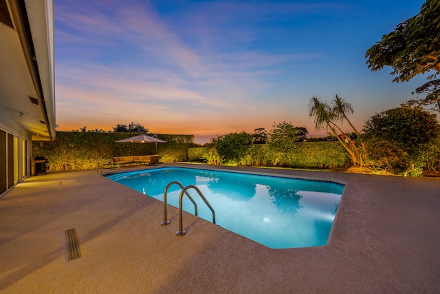 pool at dusk with a patio