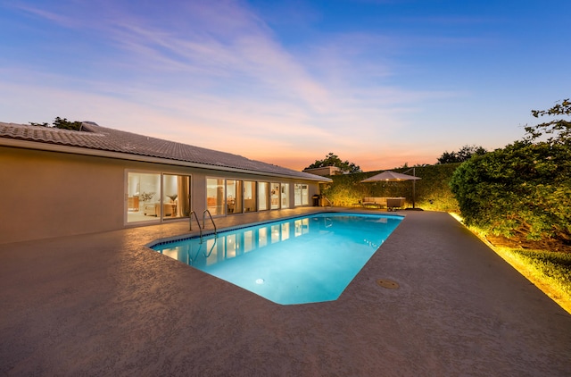 pool at dusk with a patio