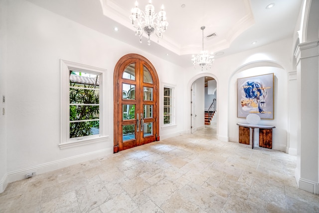 interior space featuring french doors, a notable chandelier, ornamental molding, and a tray ceiling