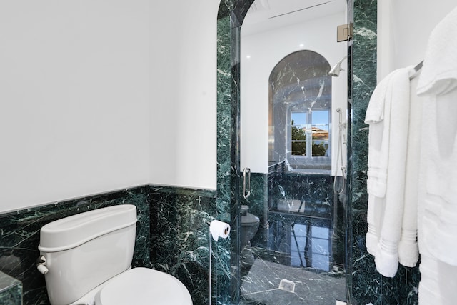 bathroom with toilet and tile walls