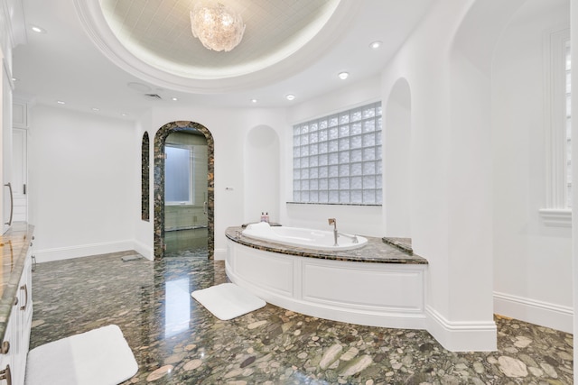 bathroom featuring a bath and a tray ceiling