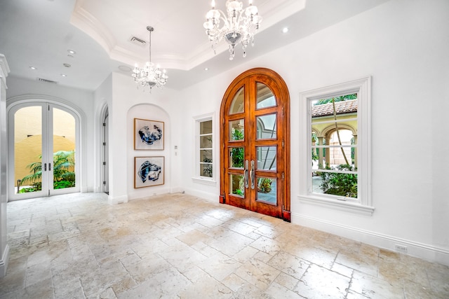 entrance foyer featuring french doors, ornamental molding, a notable chandelier, and a tray ceiling