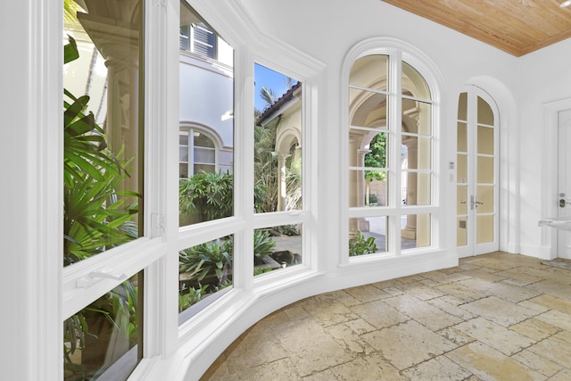 unfurnished sunroom featuring a healthy amount of sunlight and wooden ceiling