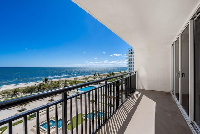 balcony featuring a water view and a beach view