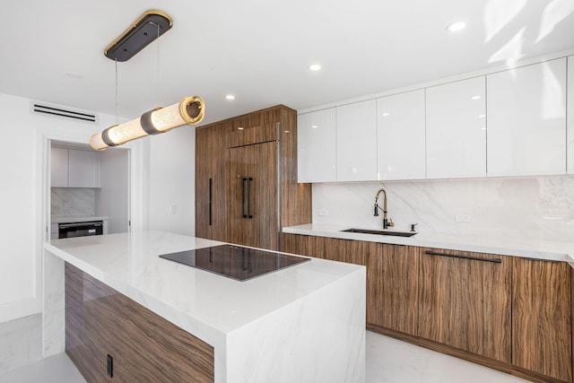 kitchen with sink, white cabinets, black electric cooktop, and tasteful backsplash