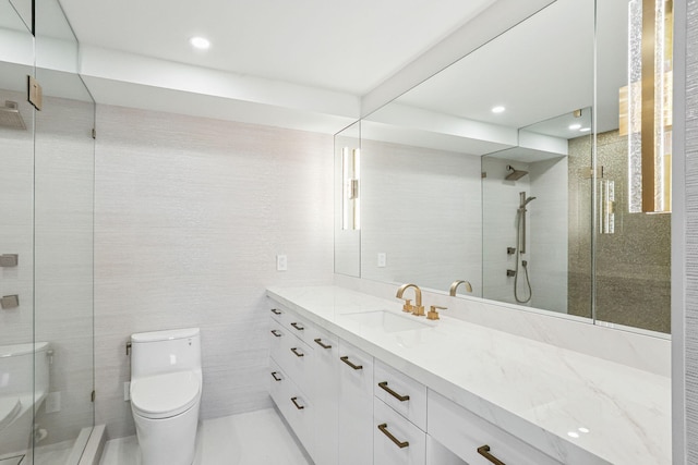 bathroom with vanity, toilet, tile walls, and an enclosed shower