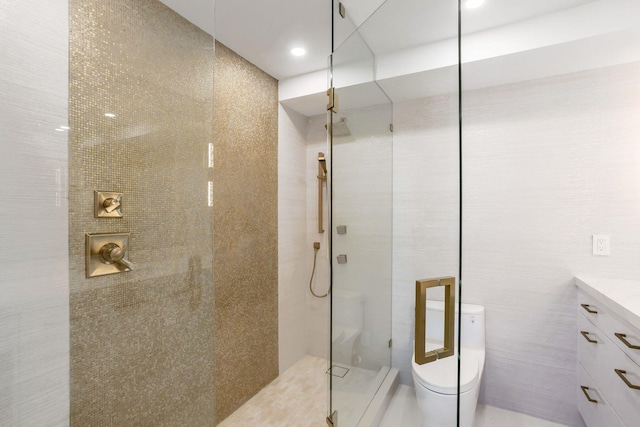 bathroom with a tile shower, toilet, and vanity